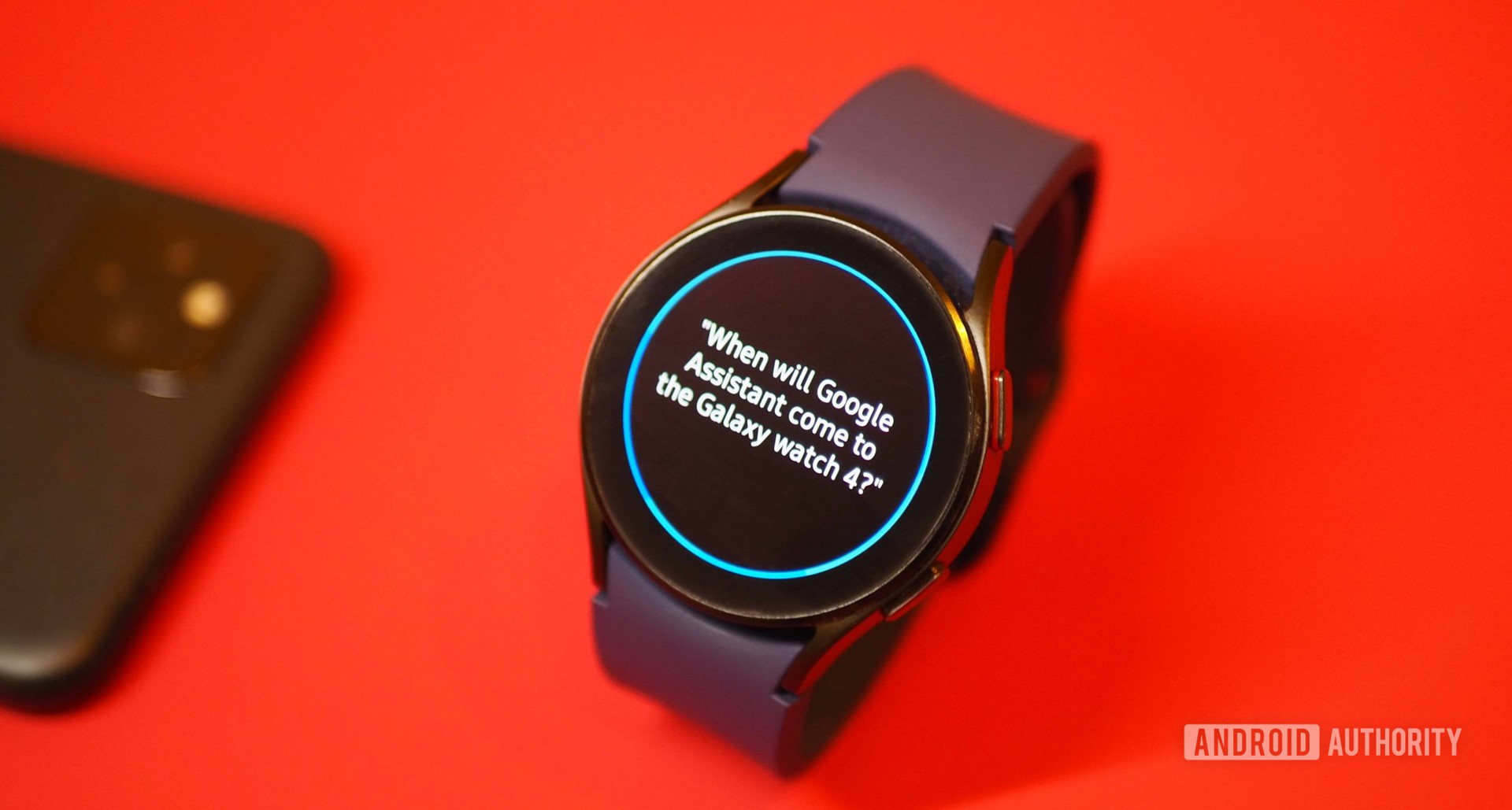 Samsung Galaxy Watch 4 em fundo vermelho, mostrando a pergunta de Bixby sobre o Google Assistente