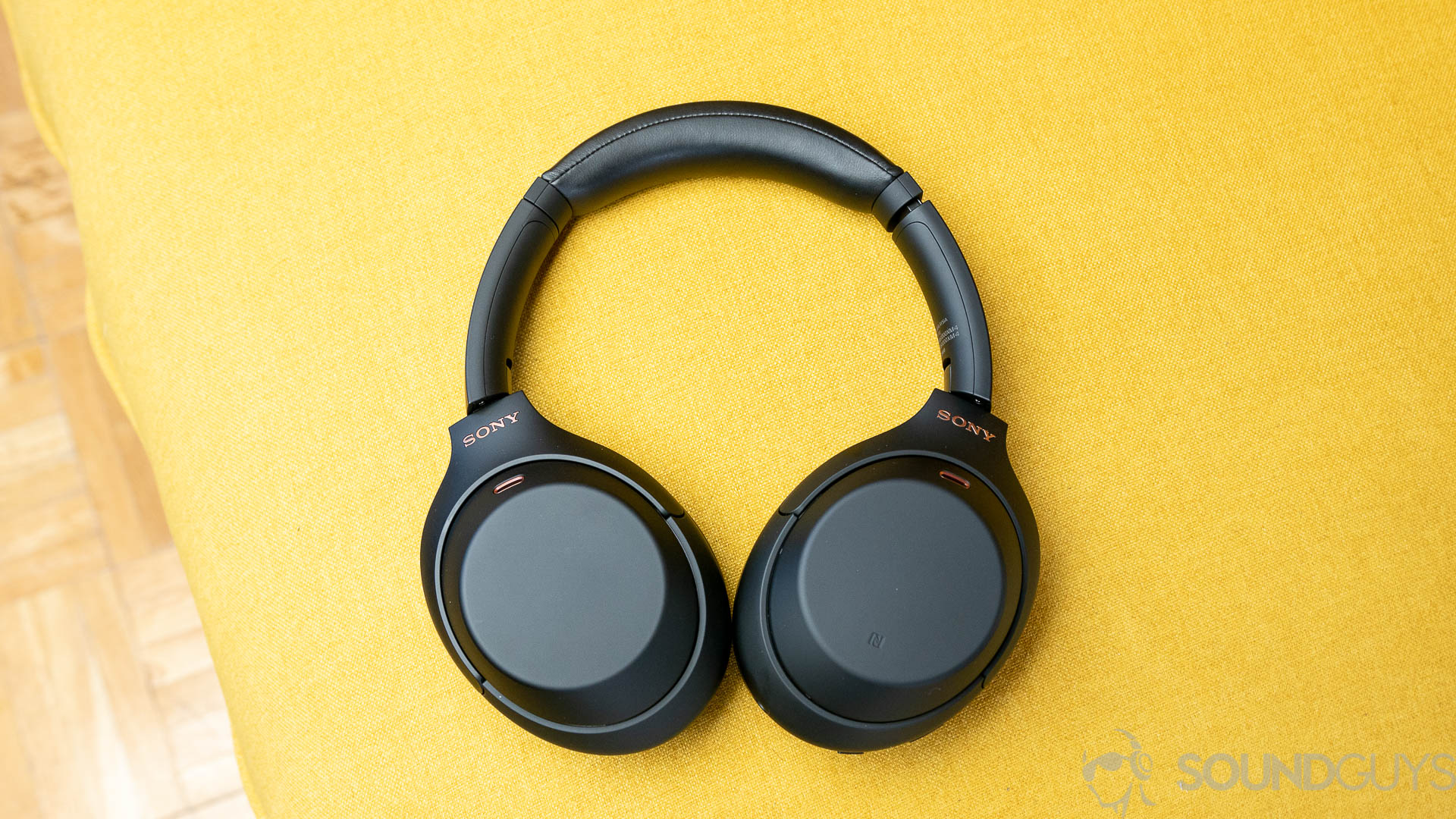 Sony WH 1000XM4 2 de 10 Os fones de ouvido Sony WH-1000XM4 em um sofá amarelo.