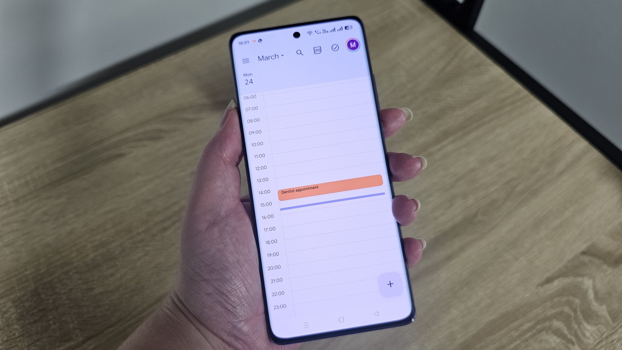 Alguém segurando um smartphone com o Google Calendar na tela