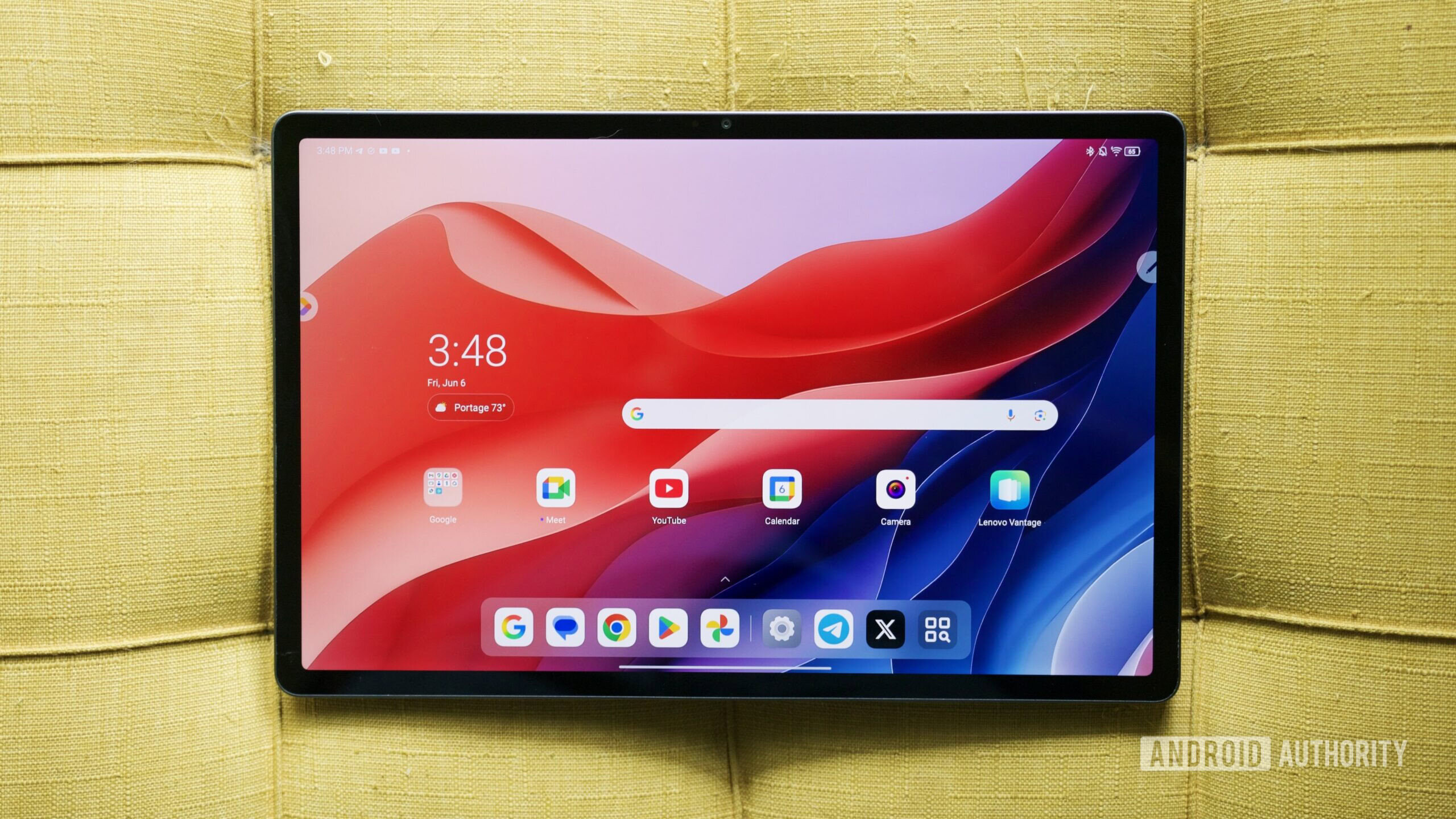 Lenovo Idea Tab Pro Revisão 13 O Lenovo Idea Tab Pro deitando um otomano amarelo.