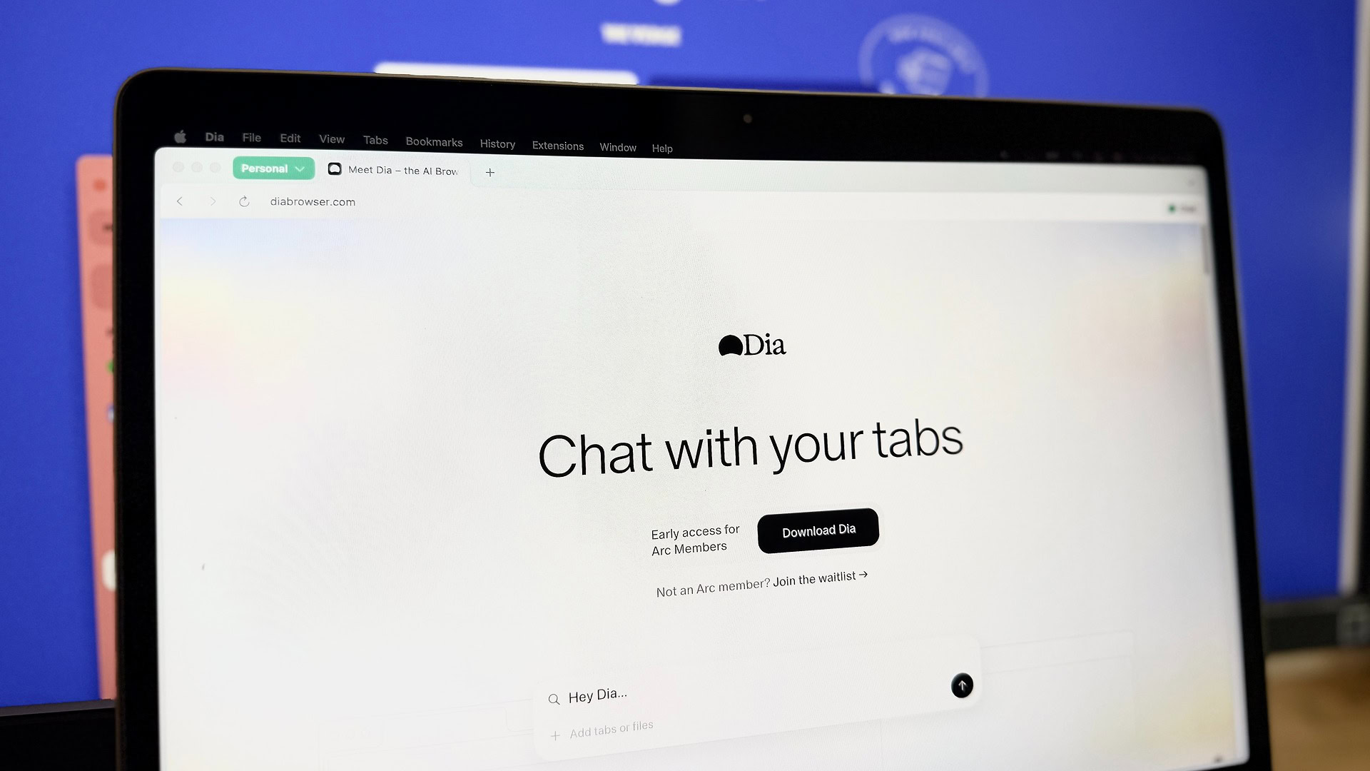 Site do navegador DIA aberto em um MacBook Air contra um fundo azul