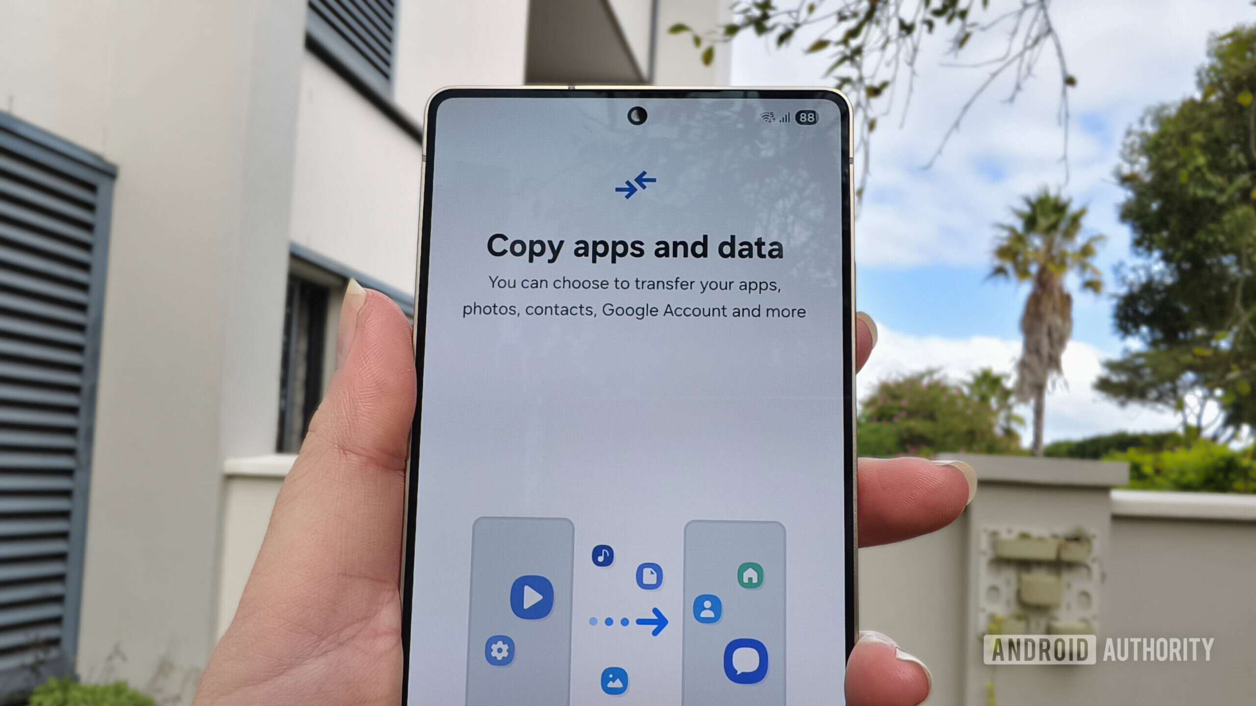 Um smartphone mantido em uma mão com um aviso para copiar aplicativos e dados Um smartphone mantido em uma mão com um aviso para copiar aplicativos e dados