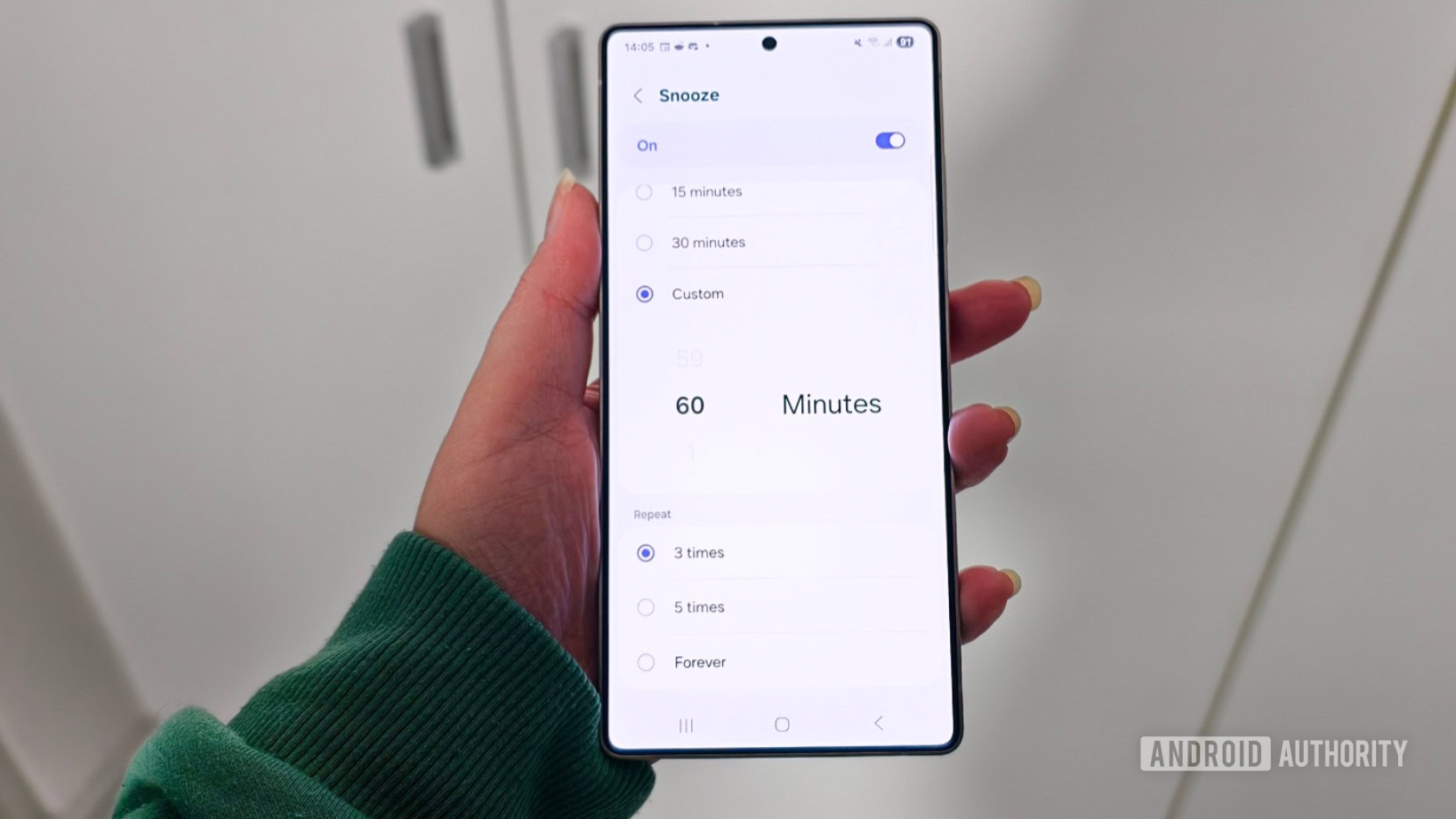 Um smartphone mantido na mão de alguém mostrando o aplicativo Samsung Clock