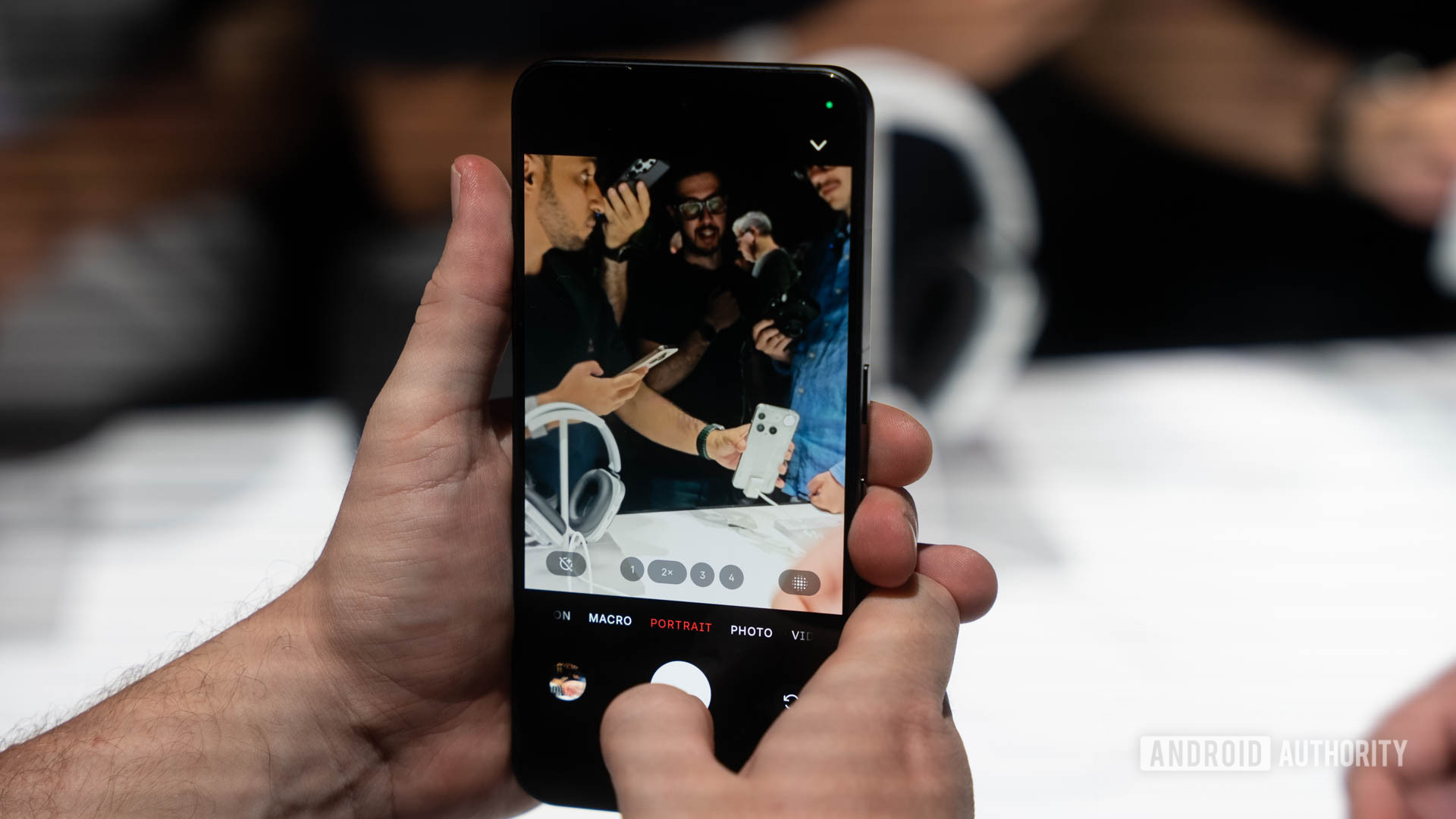 Nada telefone 3 em mãos mostrando a interface da câmera com o modo retrato destacado