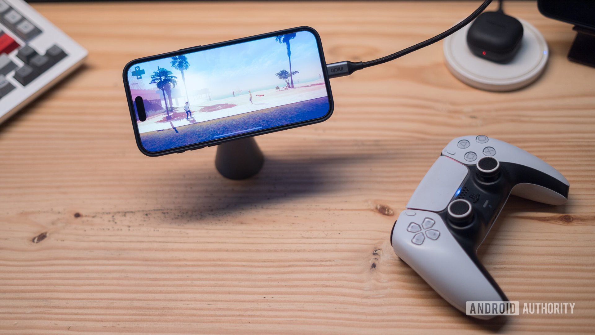 iPhone 15 Pro Max com cabo HDMI e controlador de jogo