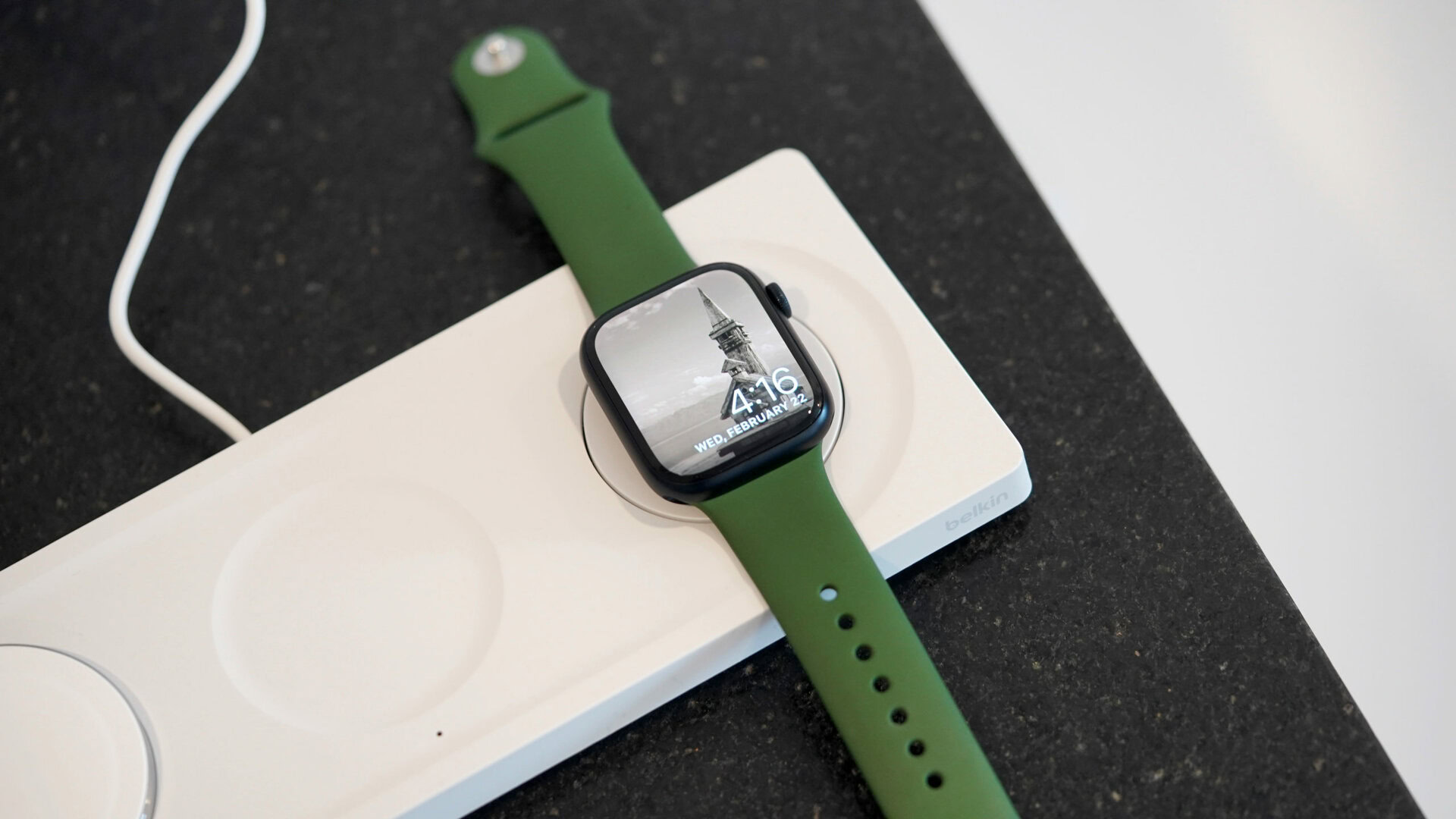 Um Apple Watch cobra deitado no Belkin BoostCharge Pro 3 em 1 carregador sem fio.