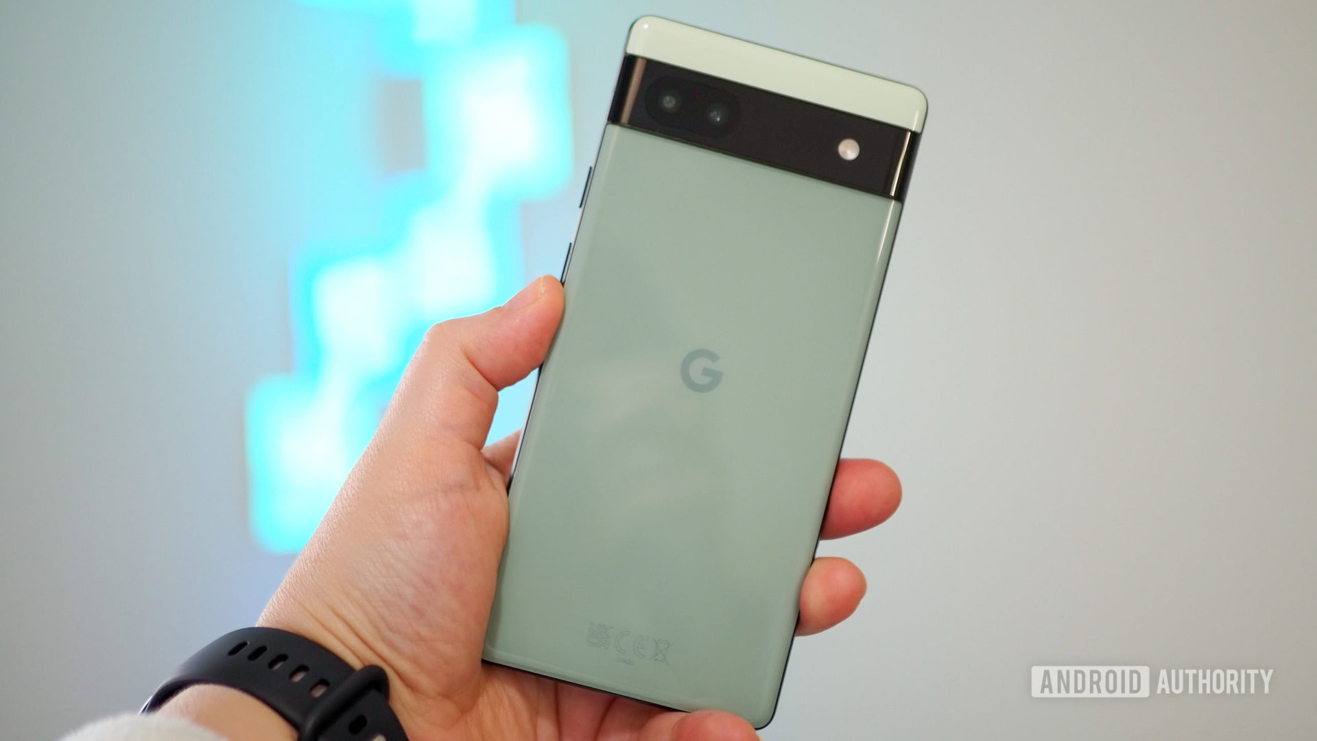 Google Pixel 6A em cor sálvia na mão, vista na parte de trás