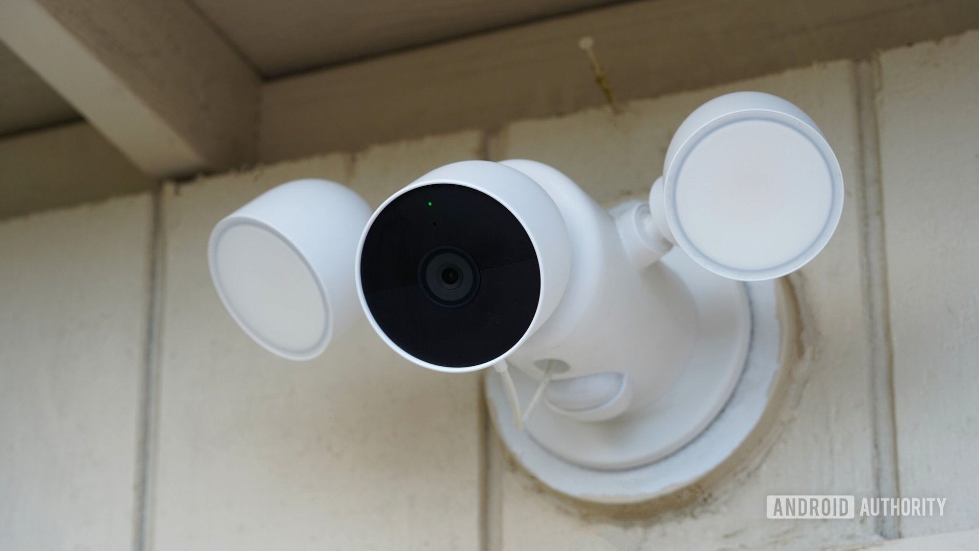 Google Nest Cam Floodlight Uma câmera do Google Nest com holofotes é anexada a um galpão.