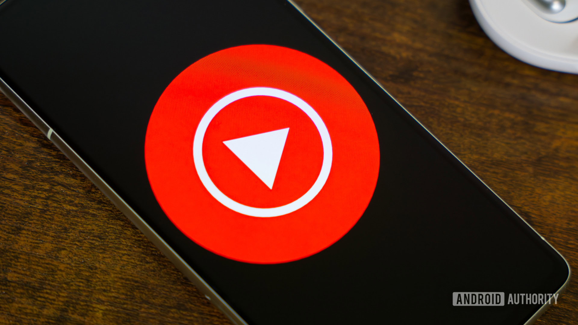 Logotipo de música do YouTube no smartphone, ao lado de fones de ouvido e Nest mini (3)