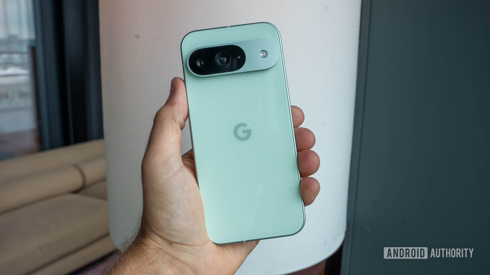 Google Pixel 9 em Wintergreen Color mantido pessoalmente a mão esquerda aparecendo de volta Google Pixel 9 em Wintergreen Color mantido pessoalmente a mão esquerda aparecendo de volta