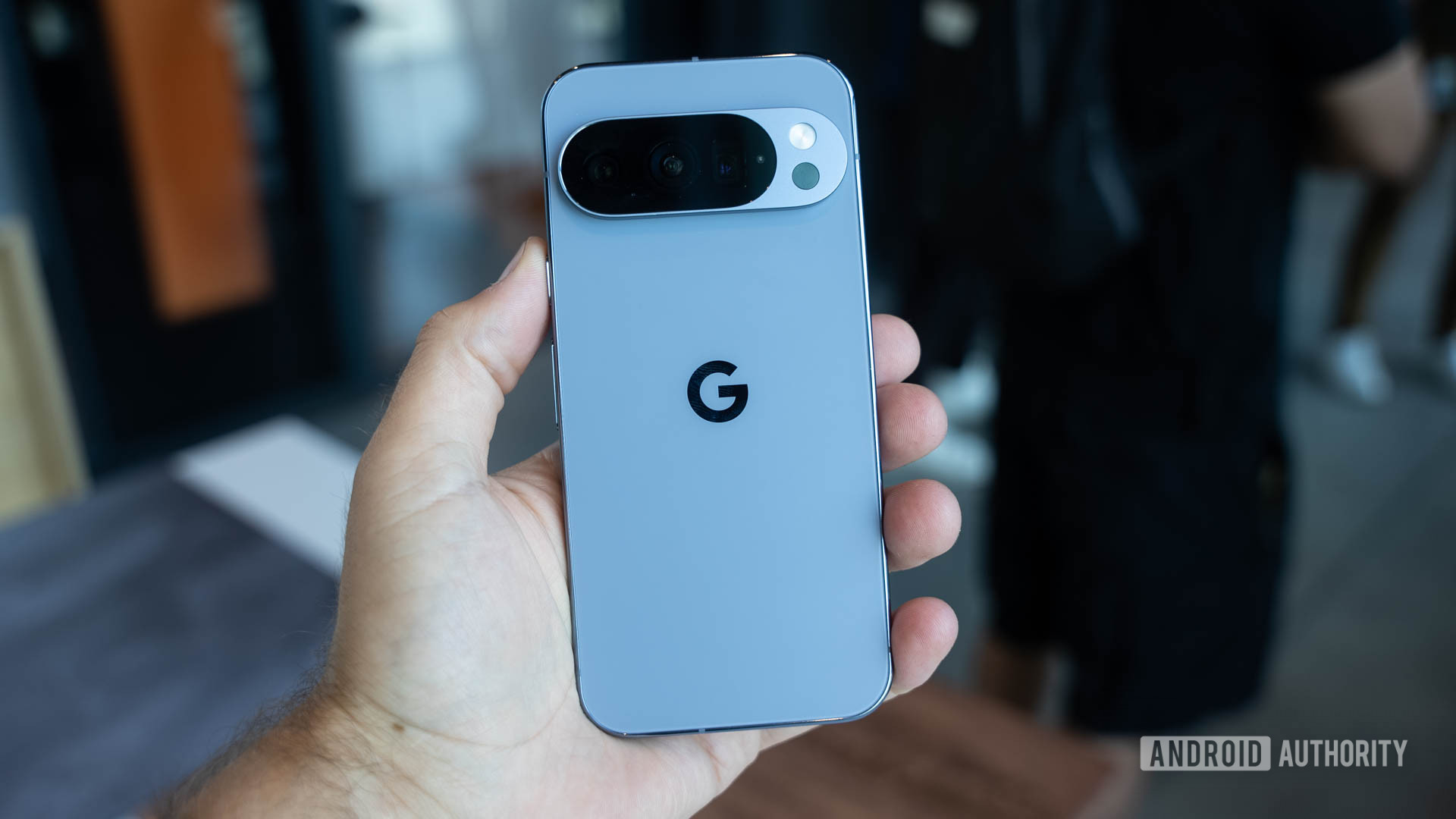 Google Pixel 10 Pro em Moonstone nas mãos de um homem aparecendo de volta