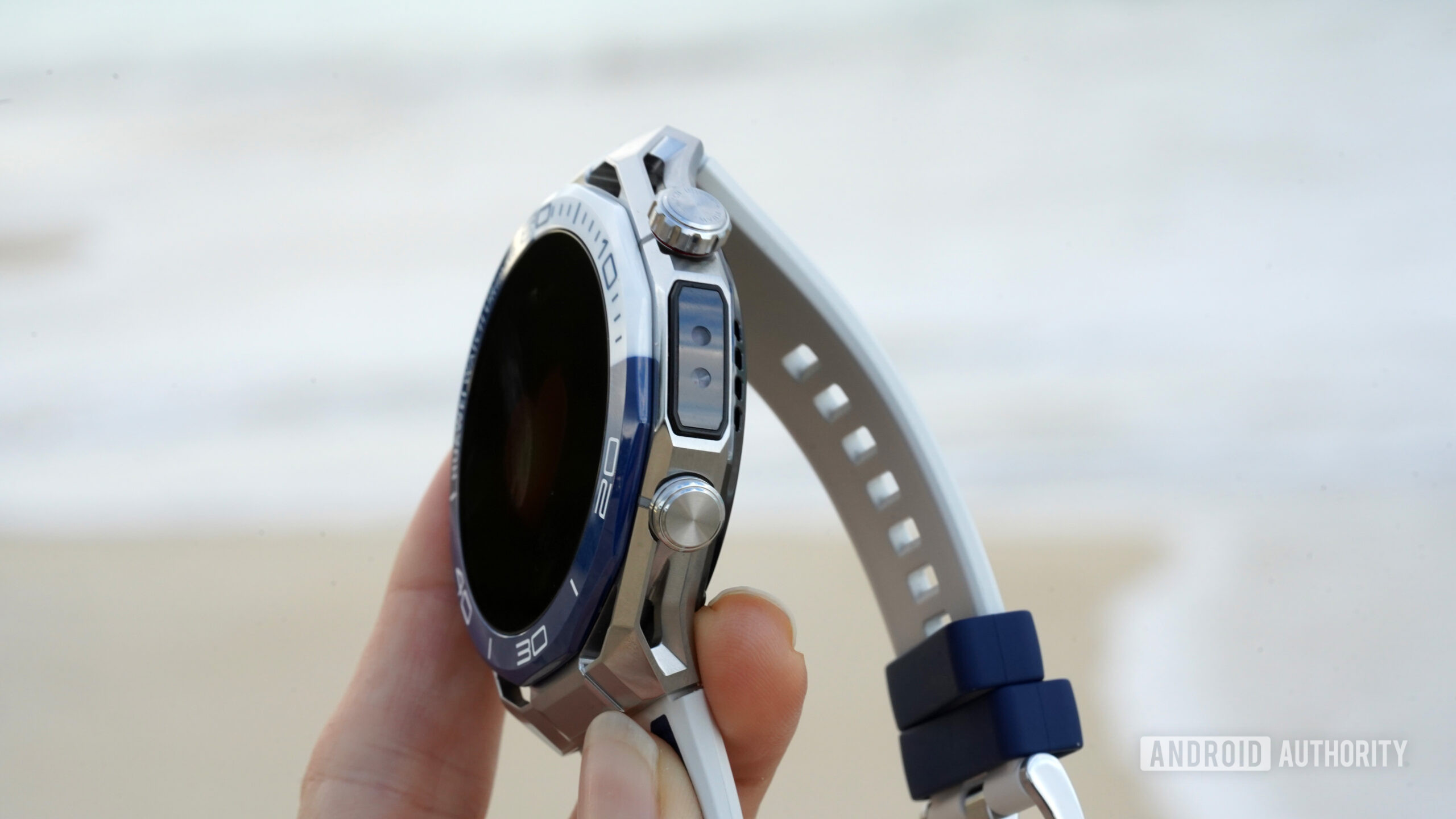 Um usuário segura um Huawei Watch Ultimate 2, mostrando o sensor X-TAP do dispositivo.