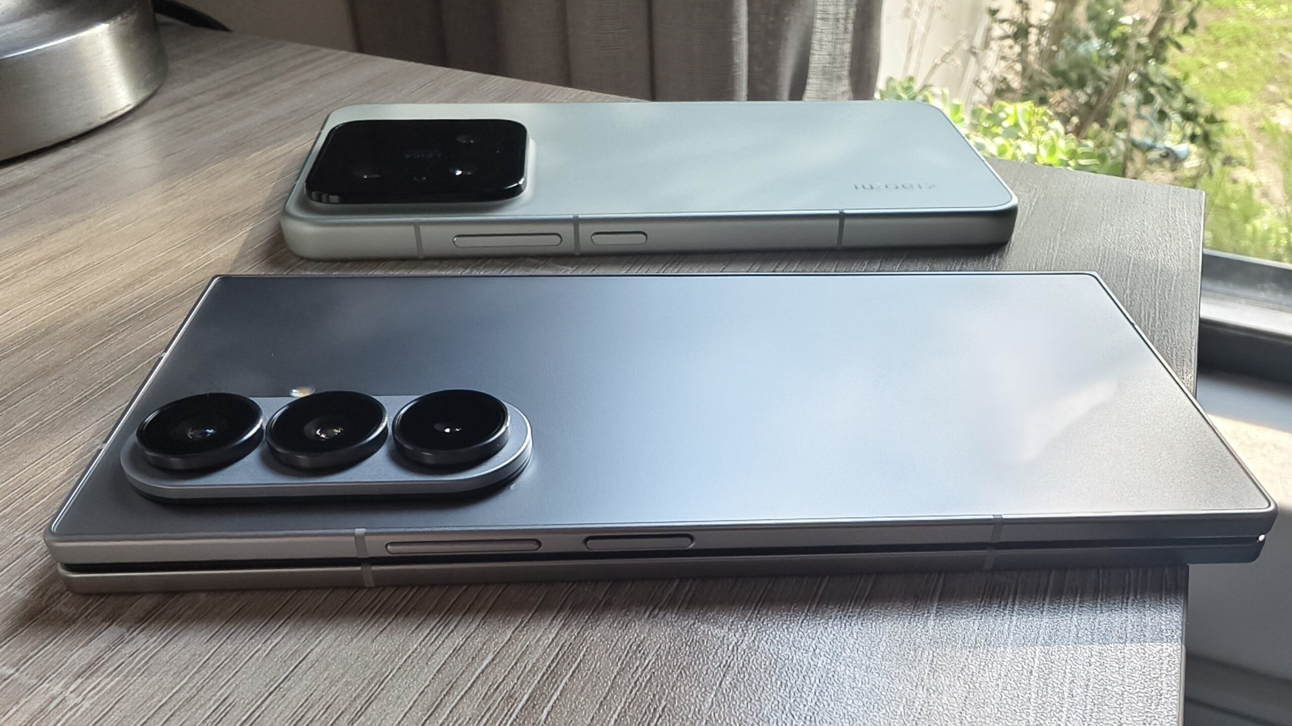 A Galaxy Fold 7 e Xiaomi 15 em uma mesa um ao lado do outro A Galaxy Fold 7 e Xiaomi 15 em uma mesa um ao lado do outro