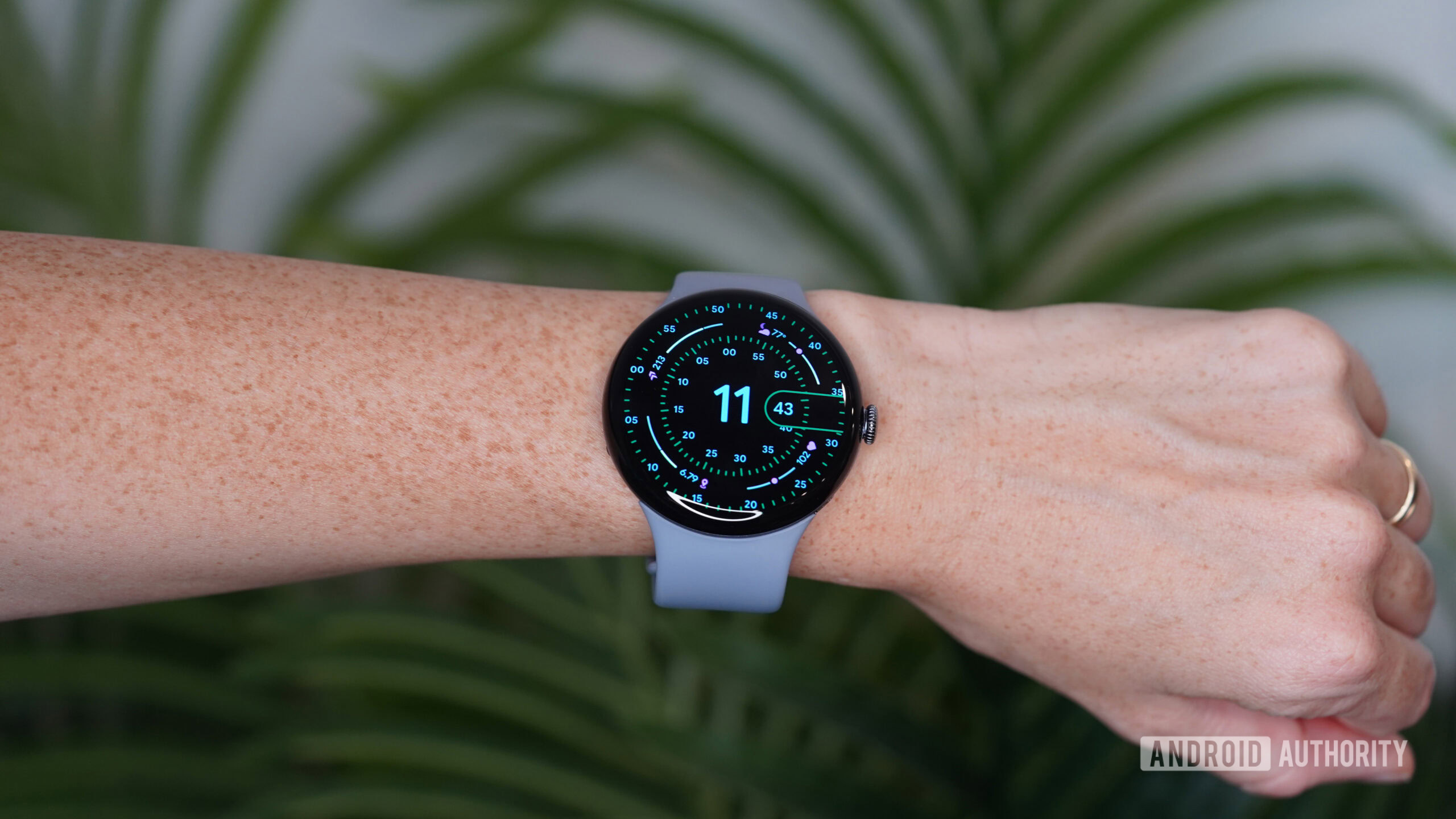 Um Pixel Watch 4 no pulso do usuário exibe um mostrador de relógio.