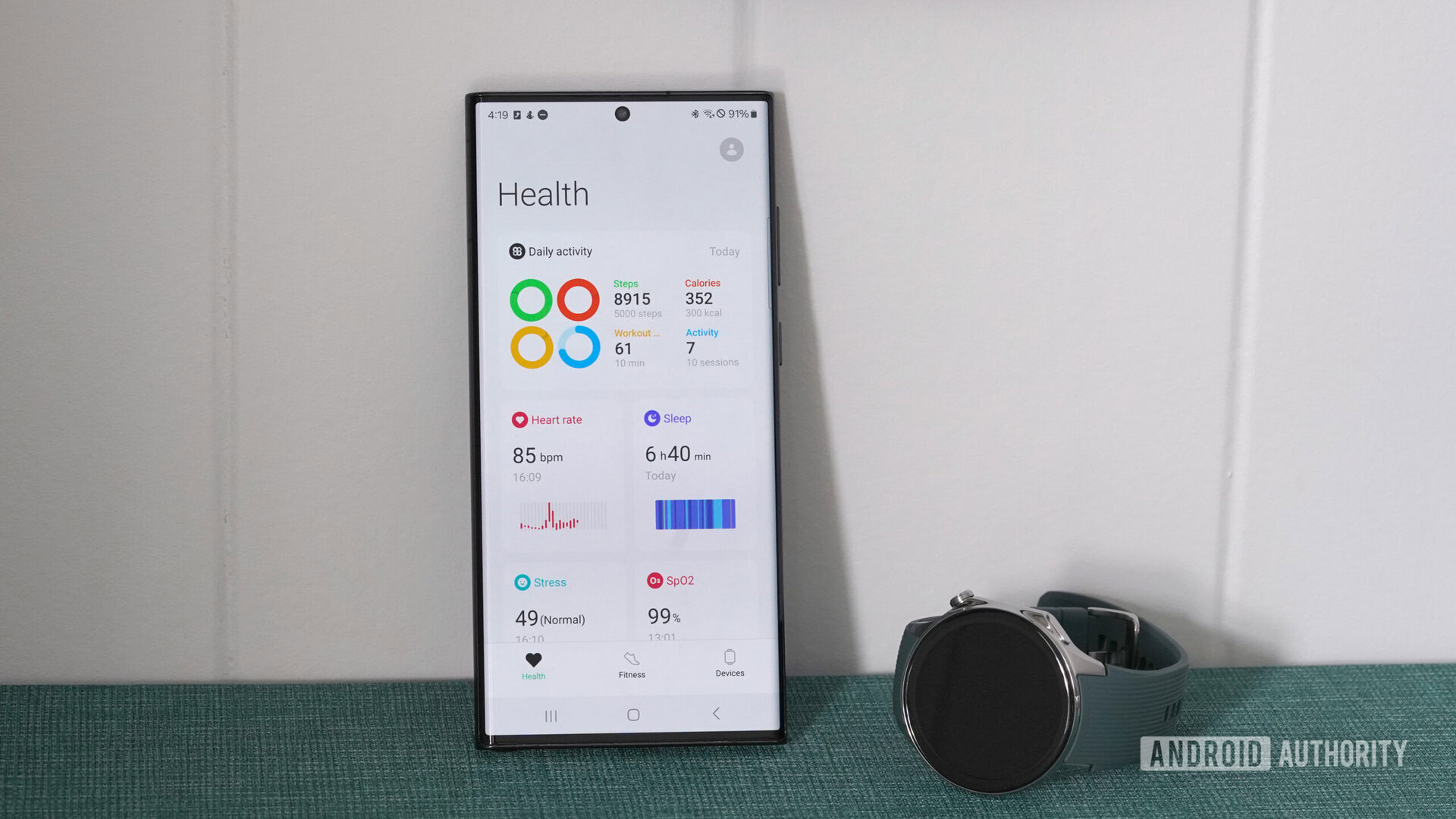 Um OnePlus Watch 2 fica próximo a um Samsung Galaxy S22 Ultra exibindo as estatísticas de saúde do usuário no aplicativo OHealth.