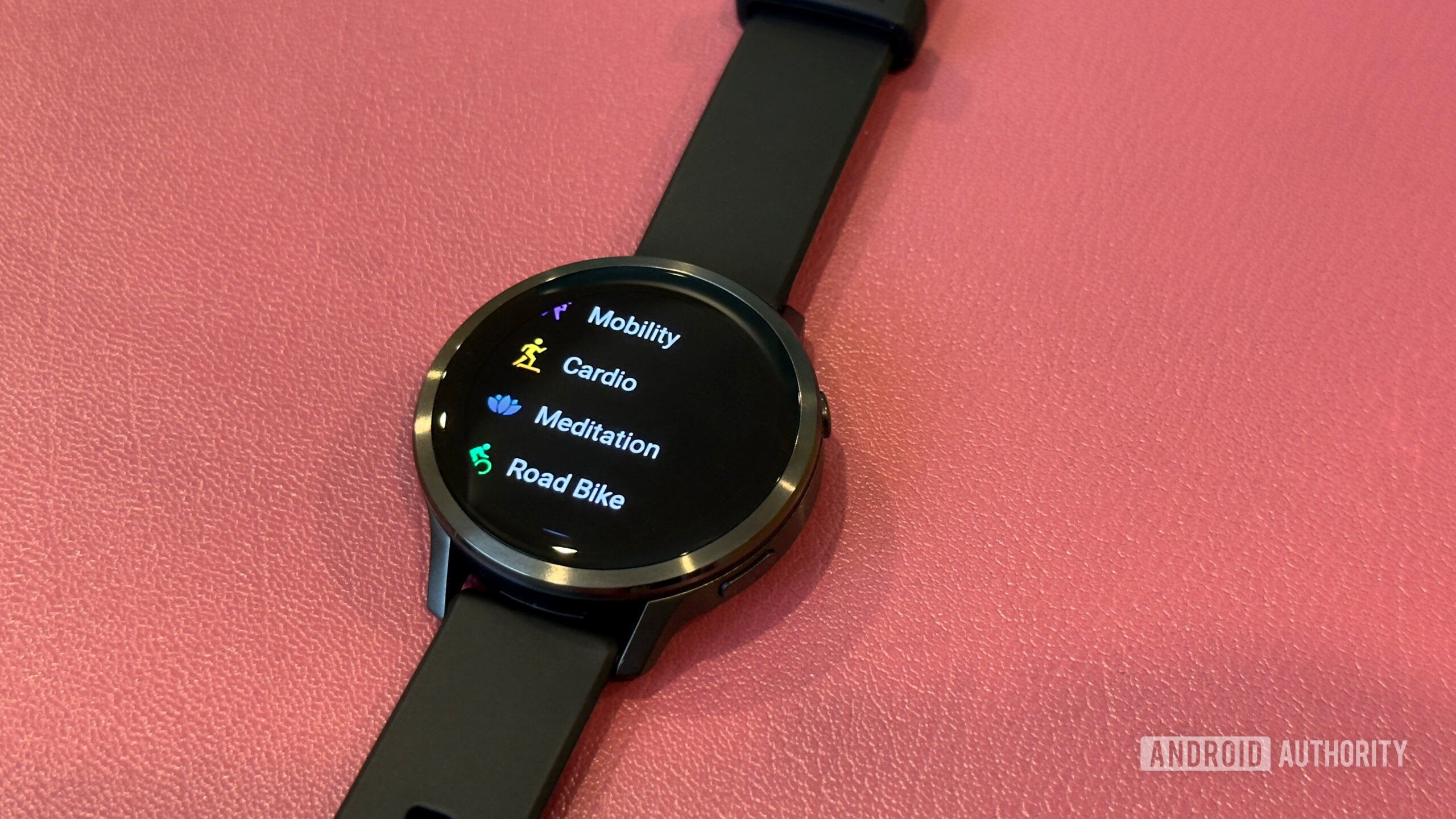 Garmin Venu 4 Um Garmin Venu 4 repousa sobre uma superfície de couro e exibe os tipos de treino.