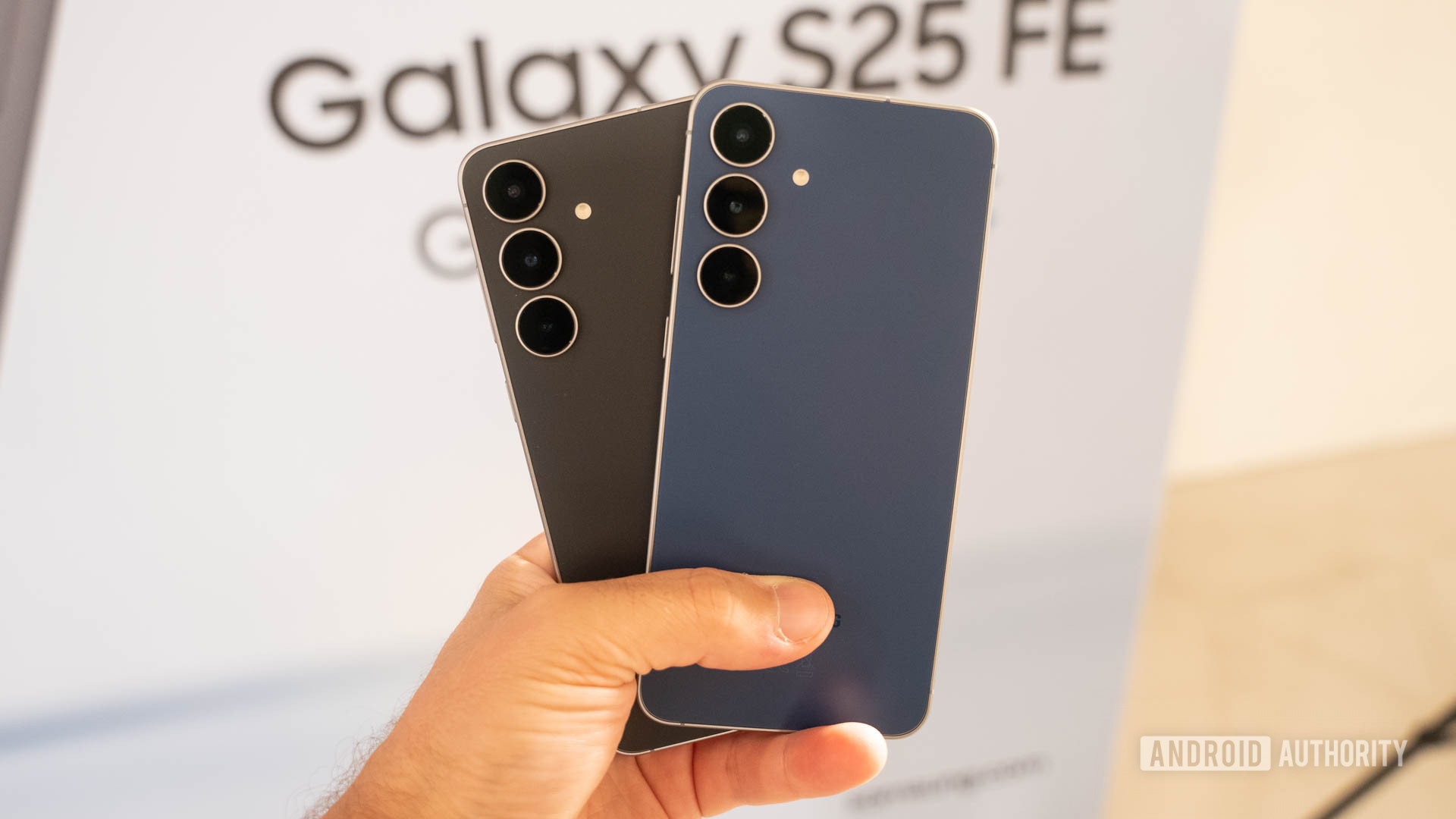 Samsung Galaxy S25 FE em Jetblack e Navy unidos na mão de um homem Samsung Galaxy S25 FE em Jetblack e Navy unidos na mão de um homem