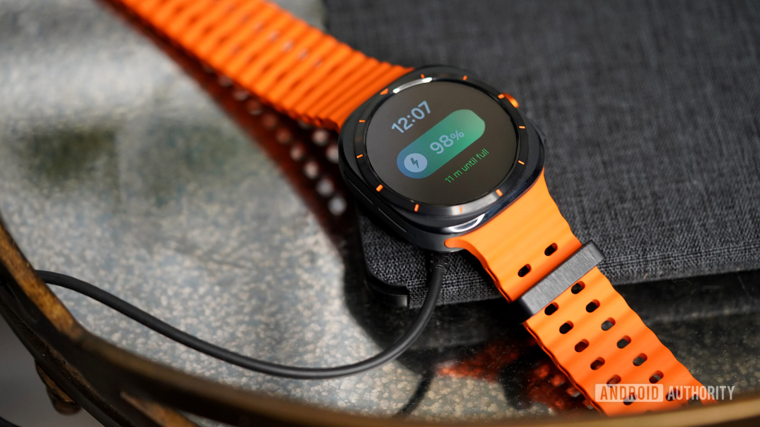 Galaxy Watch Ultra Carregamento Um Galaxy Watch Ultra está apoiado no carregador.