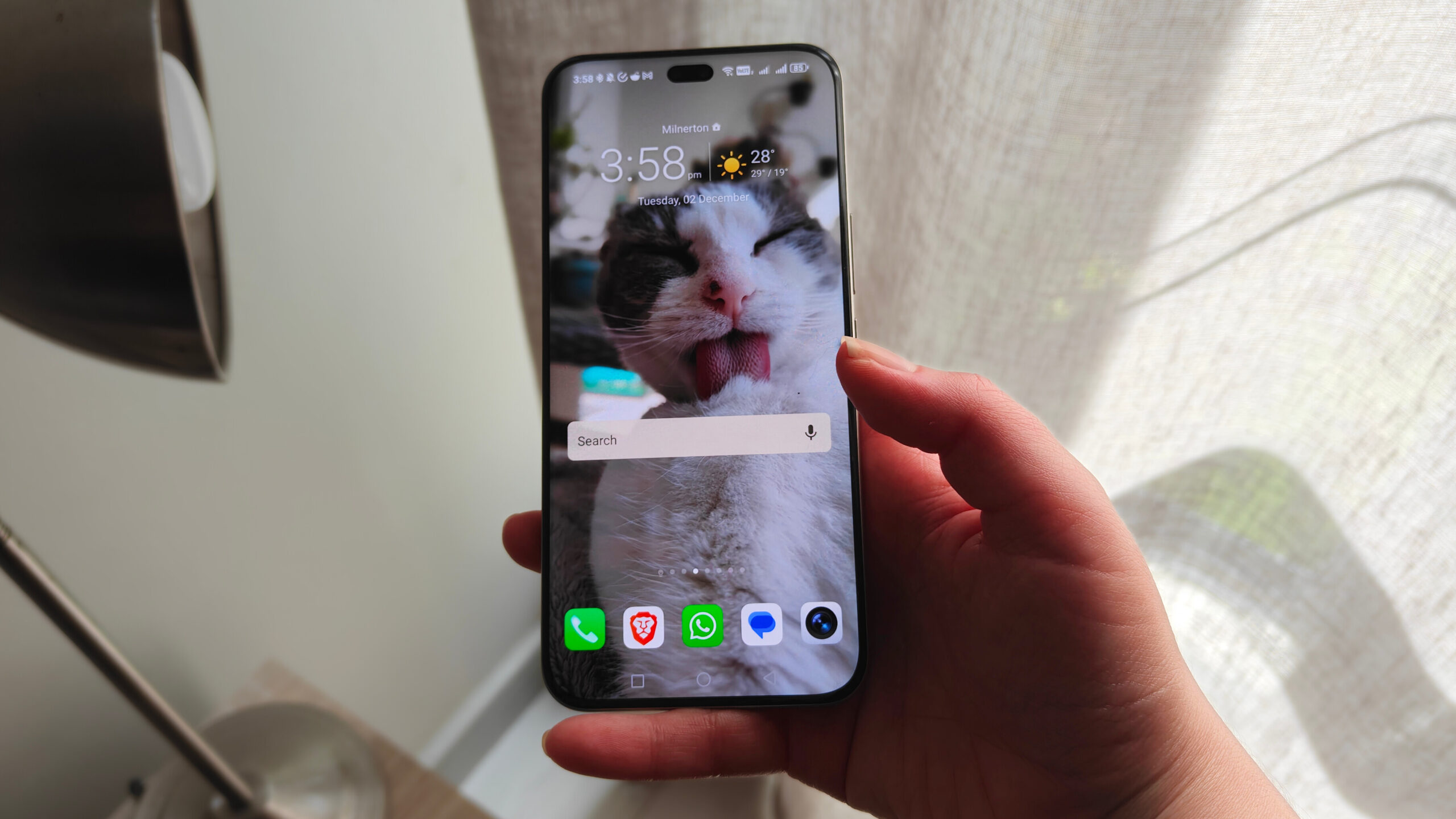 um telefone sendo segurado na mão com o dedo mínimo da pessoa na parte inferior um telefone sendo segurado na mão com o dedo mínimo da pessoa na parte inferior