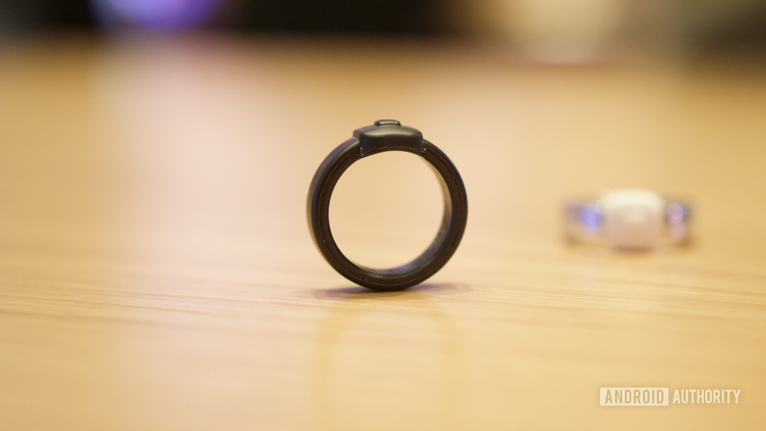 Anel Pebble Index 01 sentado em pé sobre uma mesa.