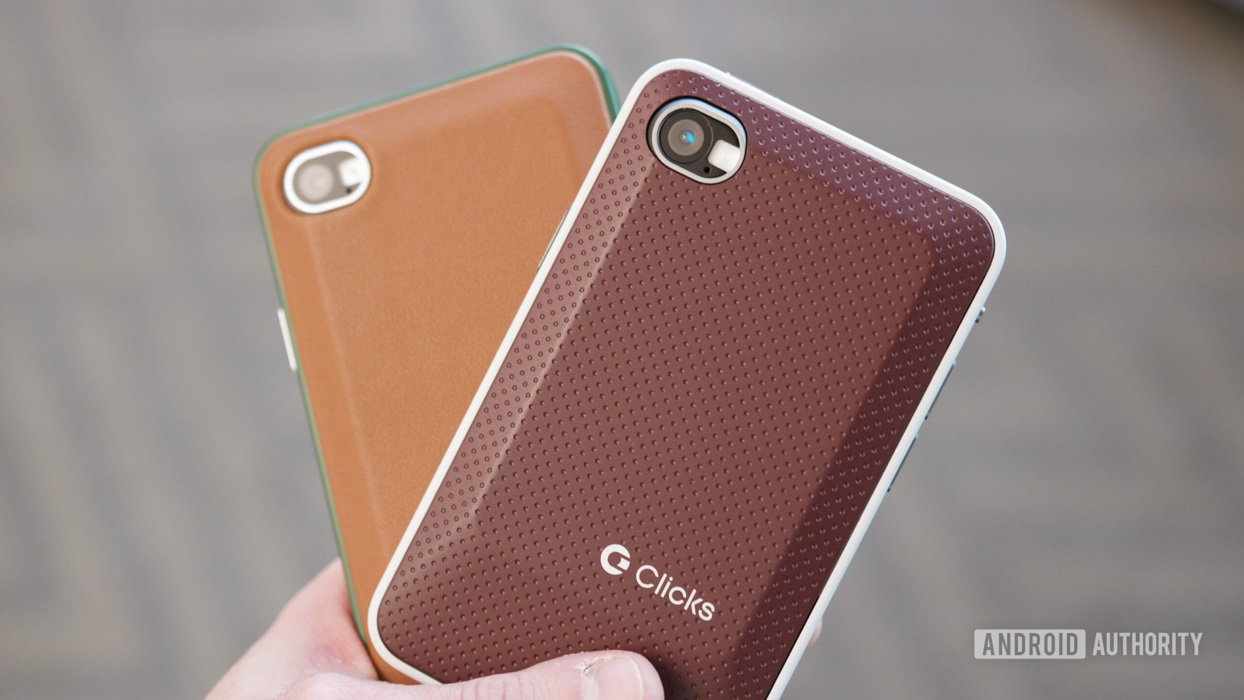 Alguém segurando dois telefones Clicks Communicator.