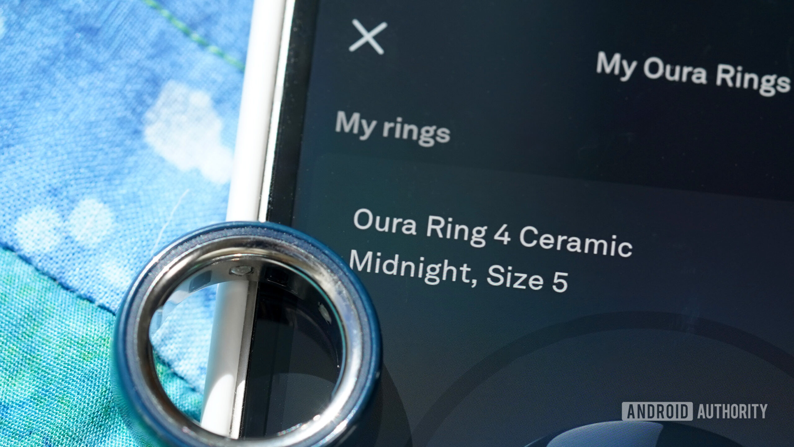 Oura anel 4 dispositivo duplo de cerâmica Um anel oura de cerâmica 4 fica no telefone emparelhado do usuário.