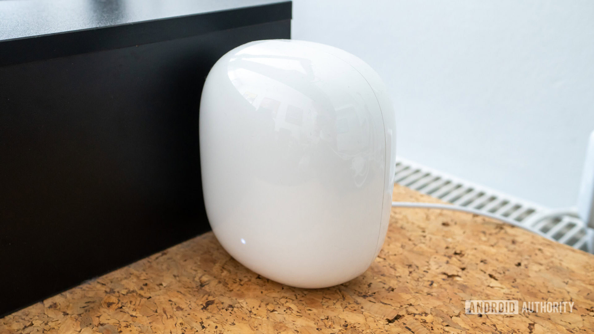 Vista angular do nó Google Nest Wi Fi Pro em uma mesa de cortiça