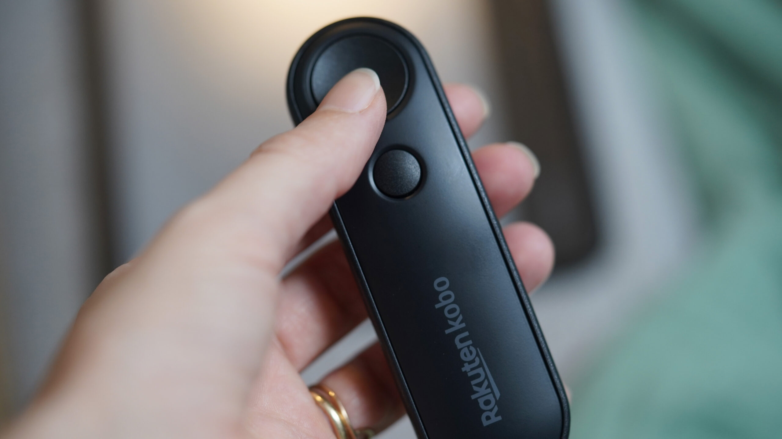 Um usuário do e-reader Kobo segura o Kobo Remote em mãos.