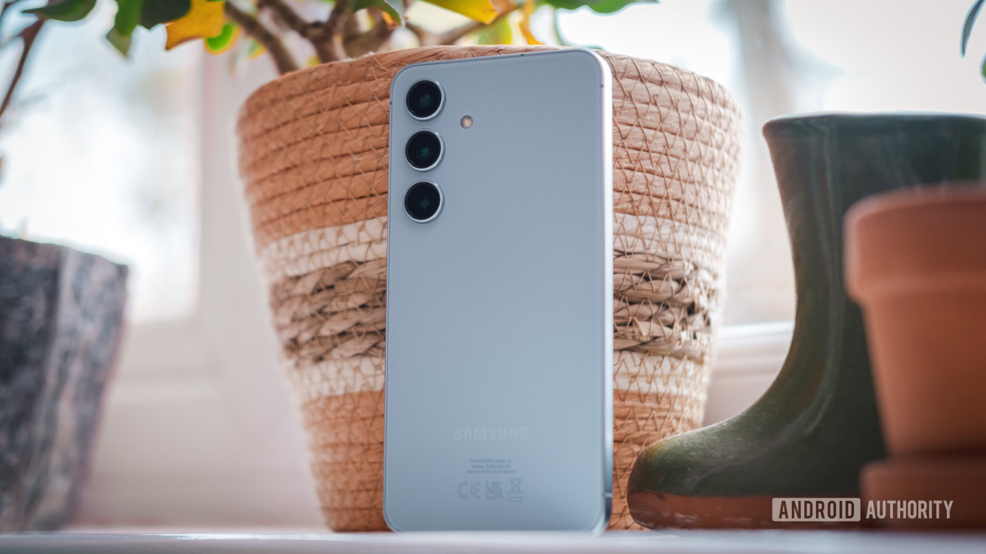 Samsung Galaxy S24 de volta contra vaso de planta