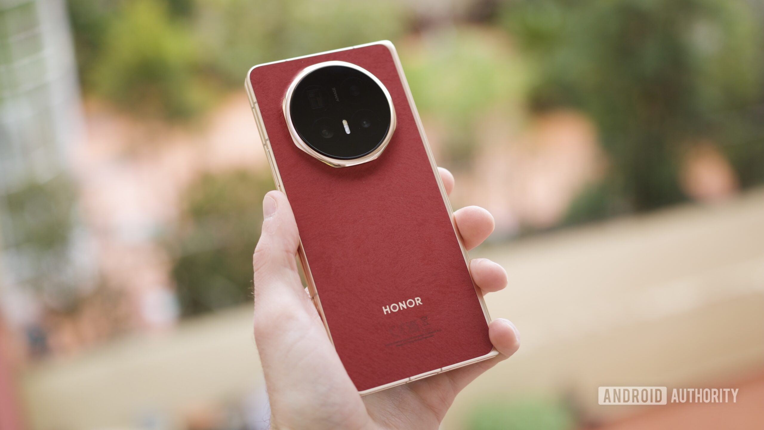 Alguém segurando o HONOR Magic V6 vermelho.