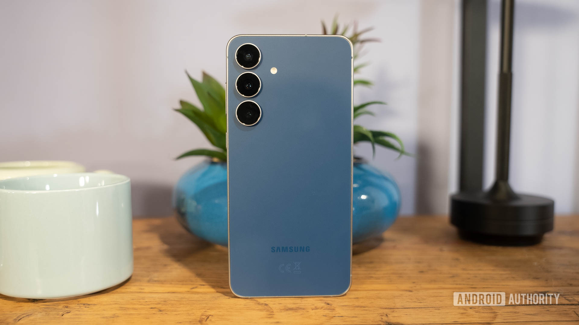 Samsung Galaxy S25 FE em Navy em frente à planta