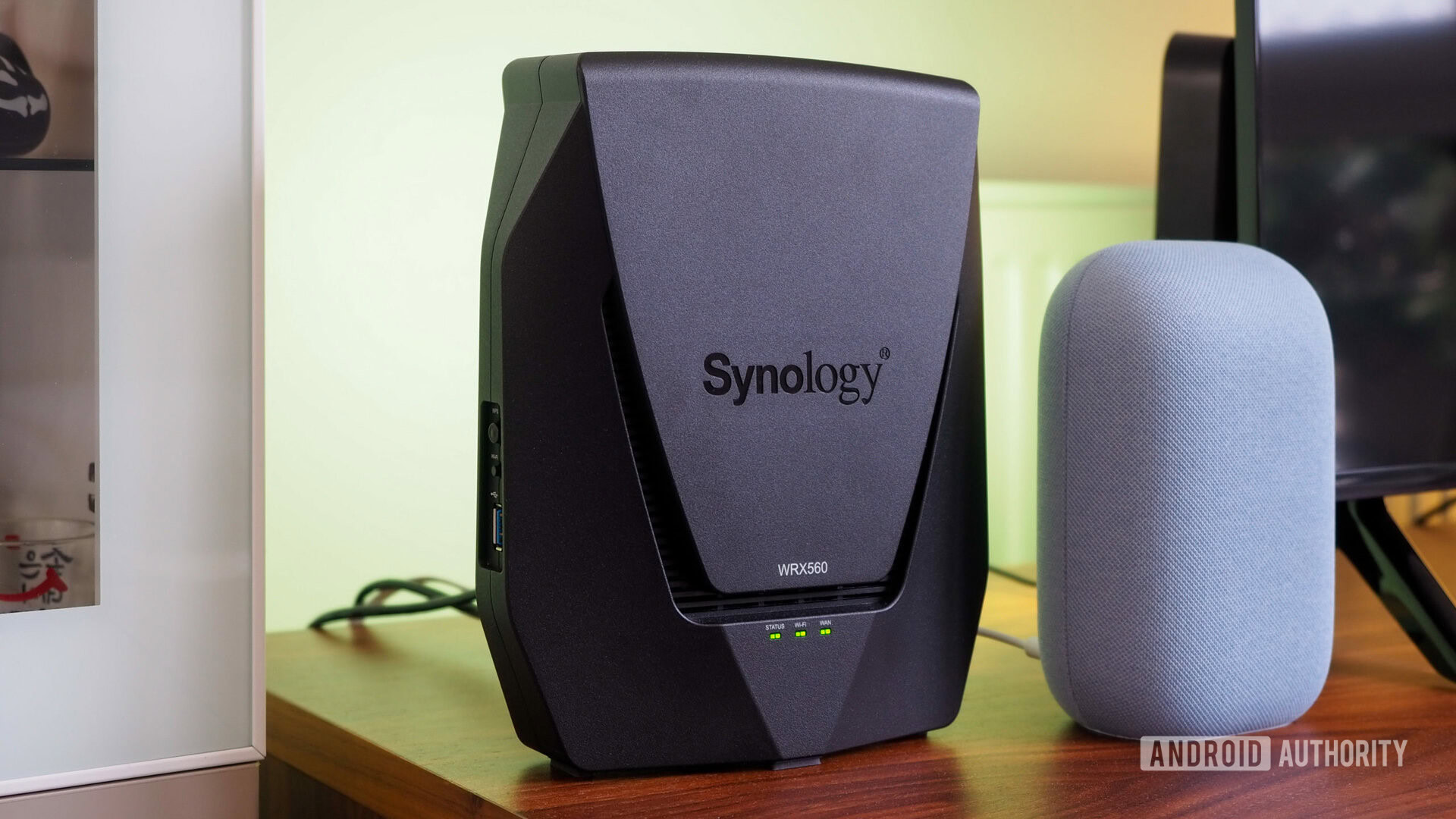 Roteador Synology WRX560 próximo a um Google Nest Audio com uma luz verde no fundo